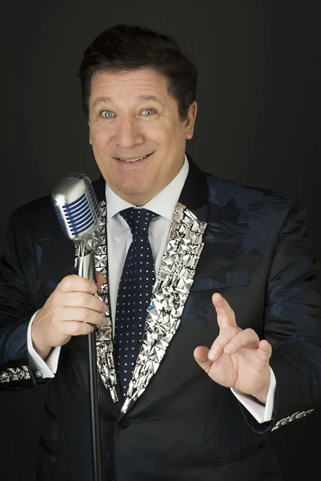 Herman José com um microfone